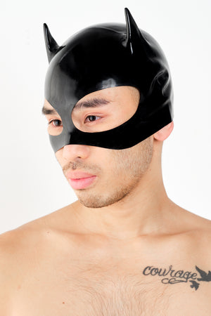 A man wearing a black latex cat mask.