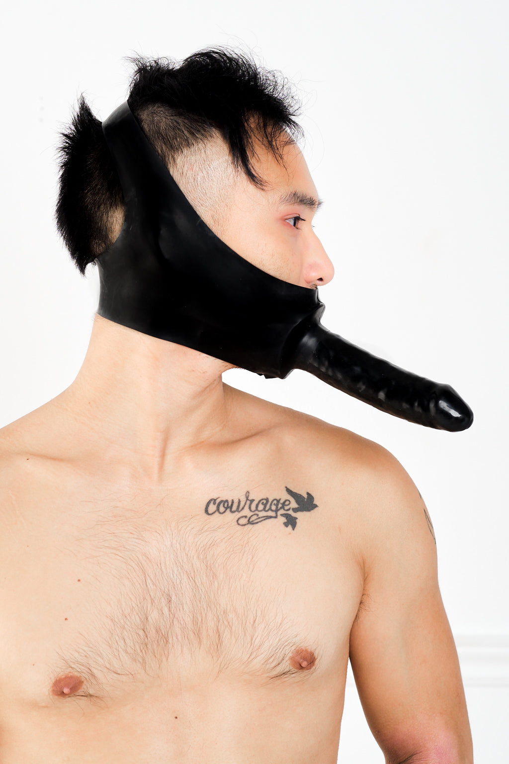 A man wearing a latex dildo mask.