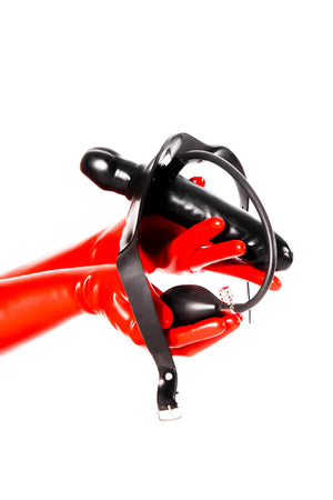 Red latex gloves holding a strap-on inflatable gag with dildo.