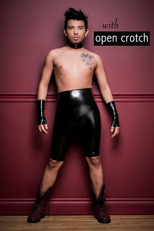 A man wearing crotchless high waisted latex bermuda shorts, black fingerless latex wrist gloves and a latex choker.