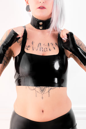 A woman in a latex camisole with a black latex choker.