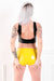 The back of a woman wearing a pair of yellow latex underwear. A rear view, showing her ass.