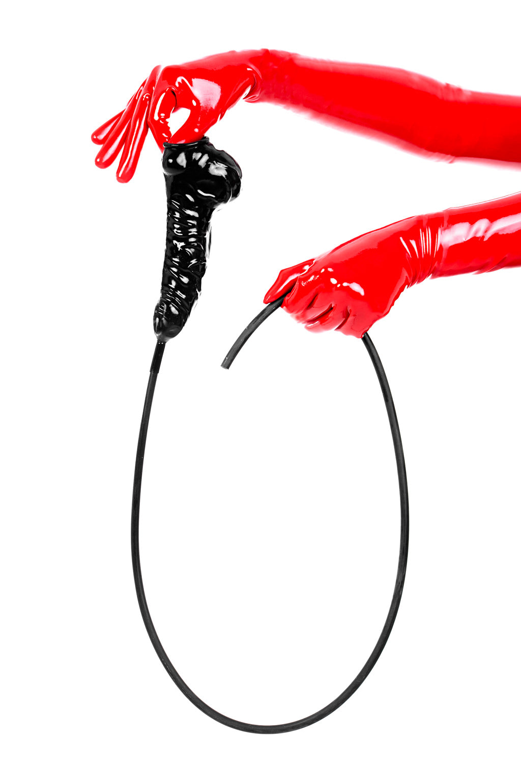Red latex gloves holding an anatomical cock and ball penis sheath with long flush tube.