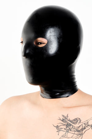 A person wearing a black anatomical latex mask.