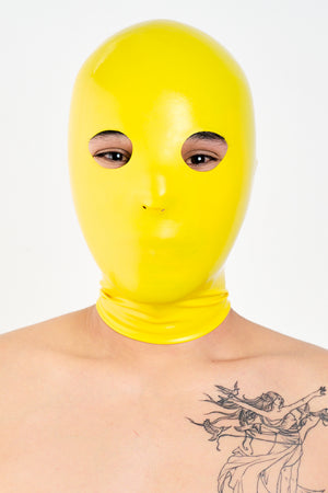 A person wearing a yellow anatomical latex mask.
