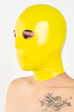 A person wearing a yellow latex anatomical mask.