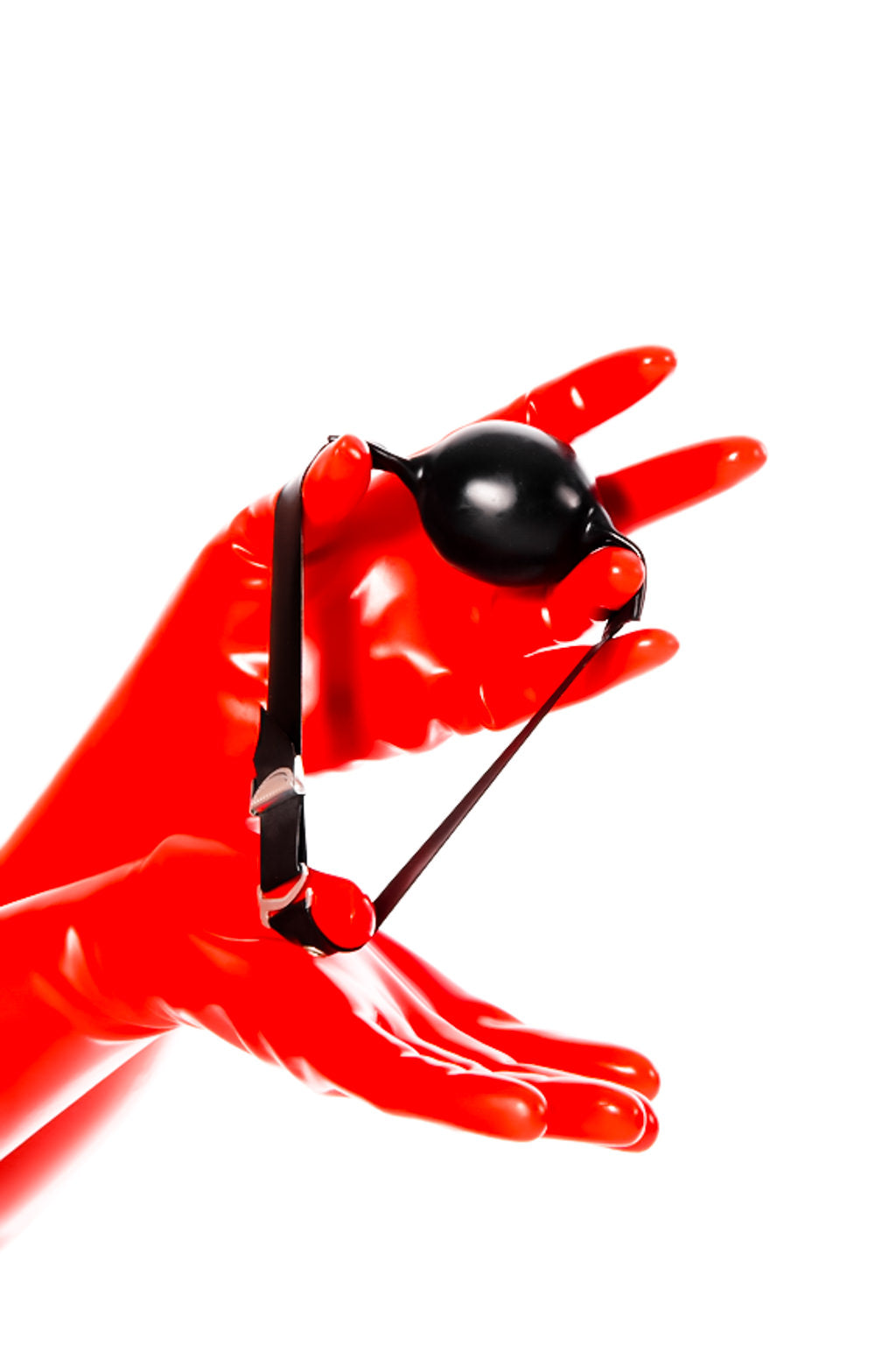 Red latex gloves holding a ball gag.