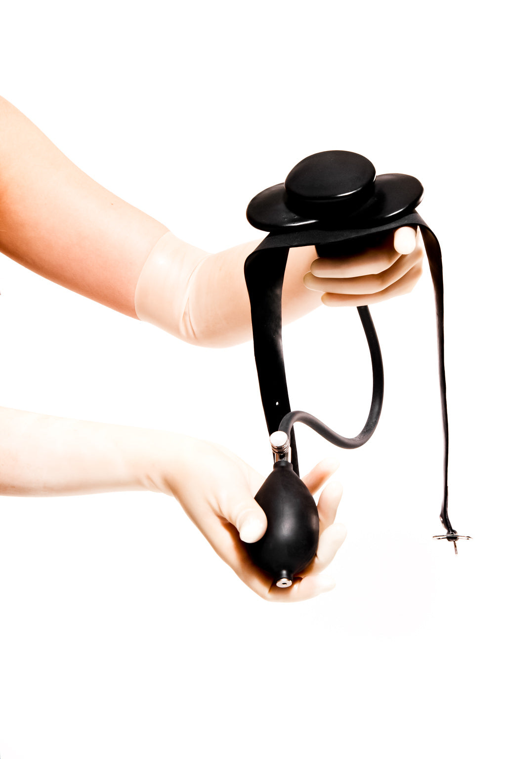 Translucent latex gloves holding an inflatable butterfly gag on a strap.