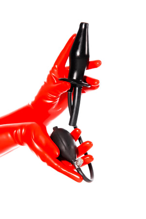 Red latex gloves holding a large inflatable enema plug.