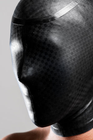 A person wearing a laser etched micro breathe latex enclosure hood.