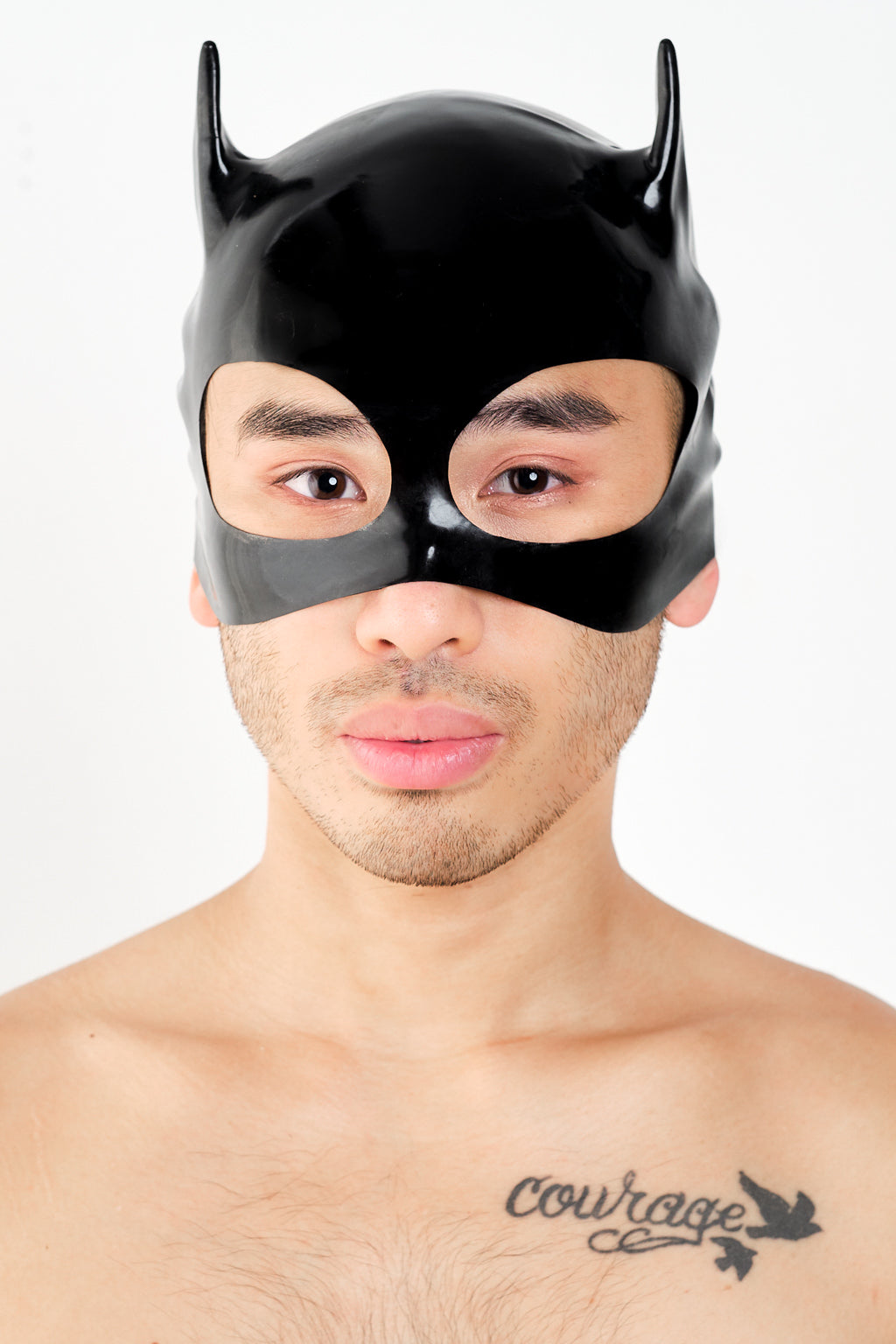 A man wearing a latex cat mask.