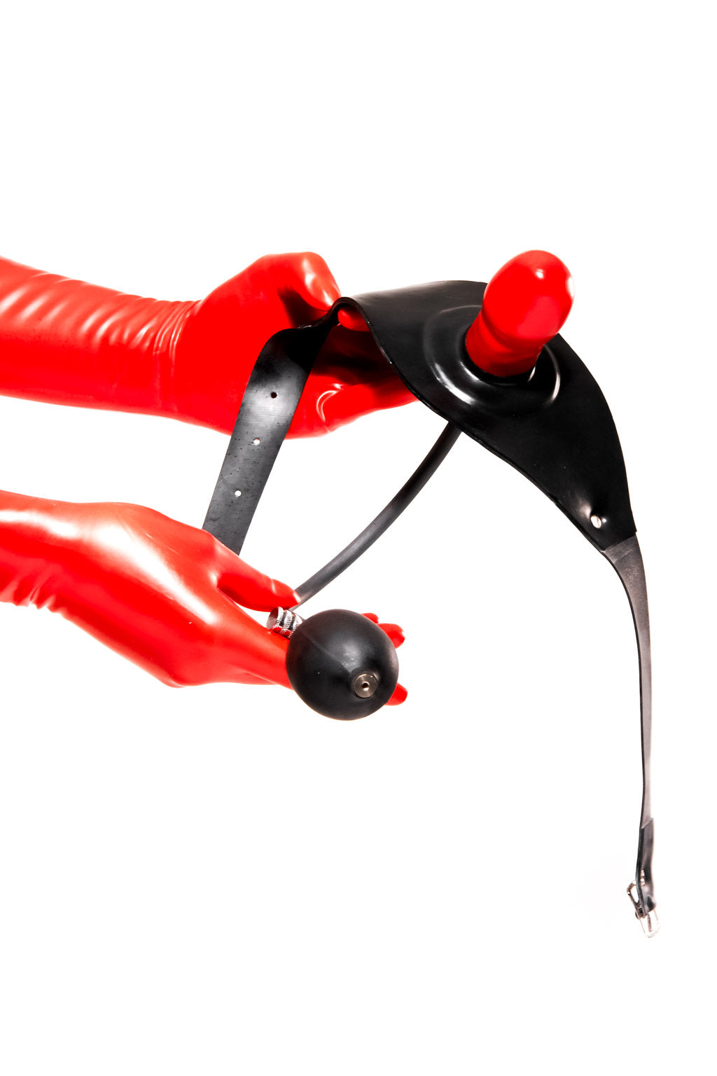 Red latex gloves holding an inflatable gag on a strap.
