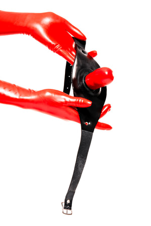 Red latex gloves holding an inflatable gag on a head strap.