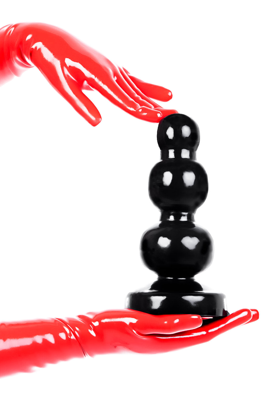 Red latex gloves holding an extra large, The Boss, butt plug.
