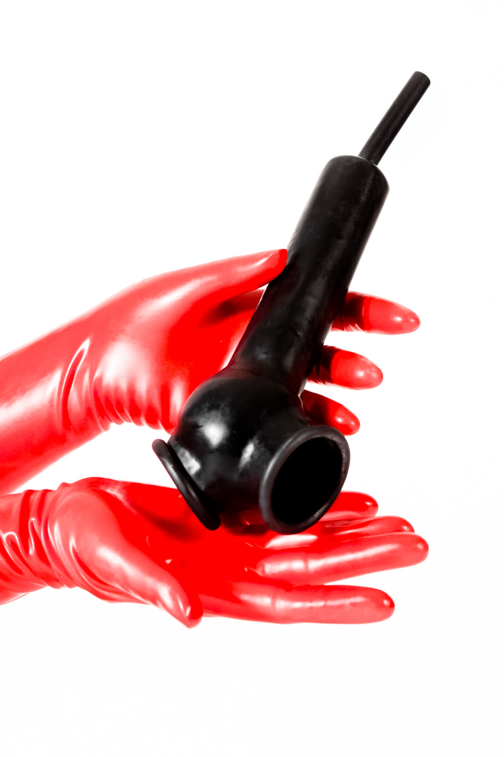 Red latex gloves holding a latex penis sheath with open ball bag and flushing tube.
