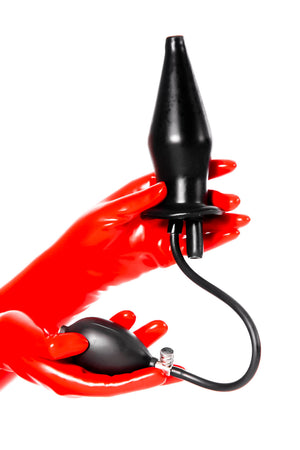 Red latex gloves holding an extra large inflatable enema plug.