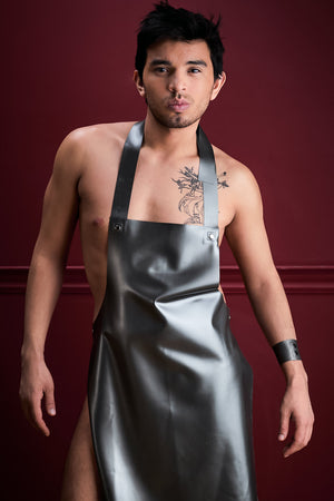 A man wearing a full length latex apron and a matching latex armband.