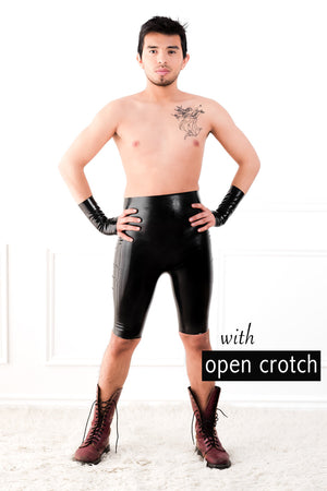 A man wearing high waisted latex bermuda shorts with open crotch and fingerless latex wrist gloves.