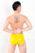 A man wearing yellow latex underwear with a penis sheath. A rear view, showing his ass.