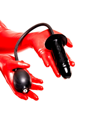 A pair of red latex gloves holding an inflatable butt plug.