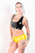 A woman wearing a pair of yellow latex panty briefs and a latex crop top.